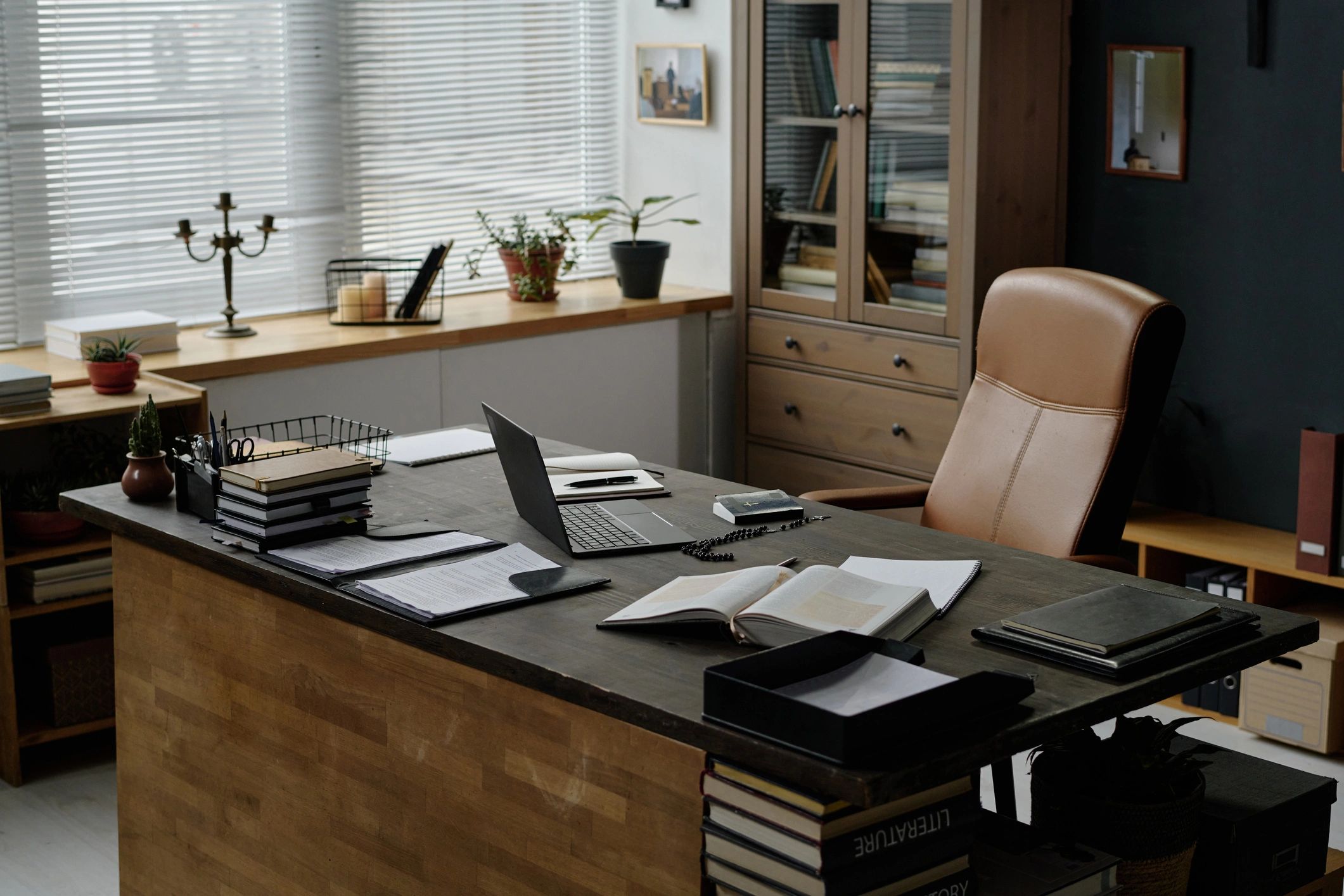 Desk with books and laptop in an office setting